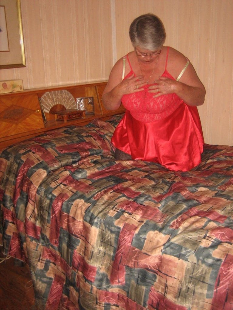 Fat granny Girdle Goddess pets her pussy after stripping to hosiery on her bed