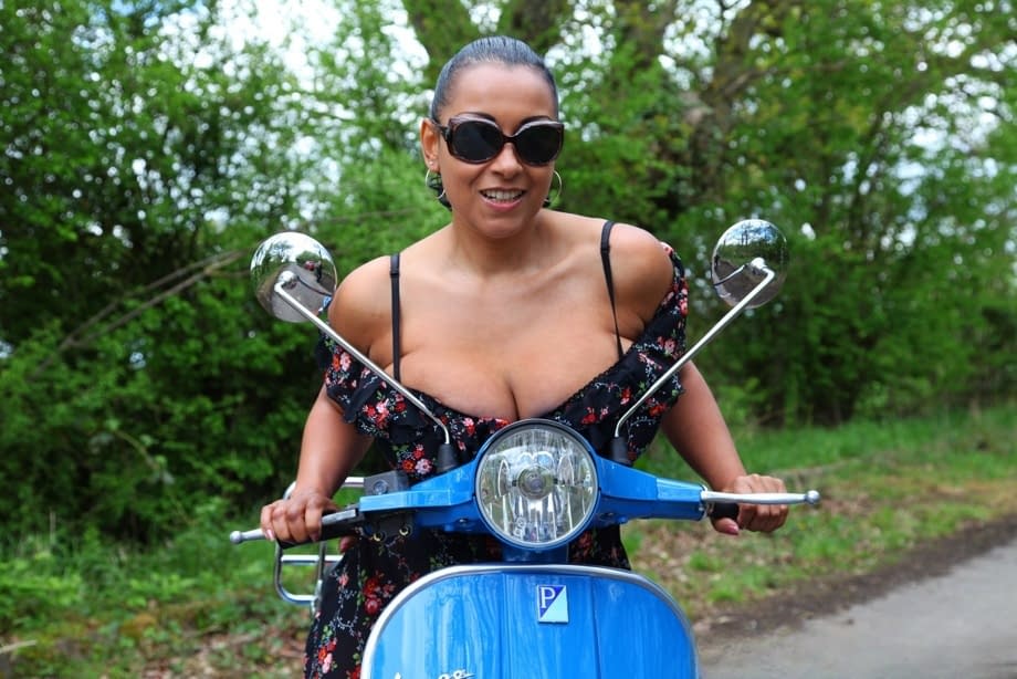Mature lady Danica Collins exposes large tits and twat on a scooter