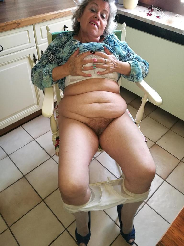 Horny granny Caro sticks a banana inside her natural pussy on kitchen chair