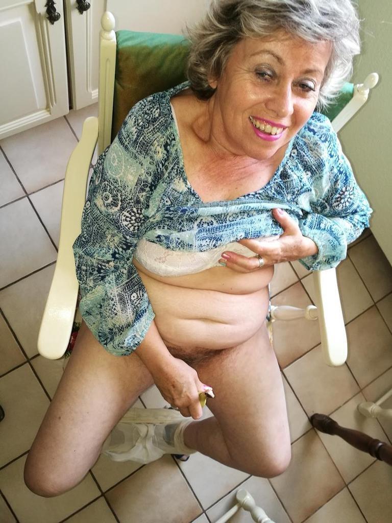 Horny granny Caro sticks a banana inside her natural pussy on kitchen chair