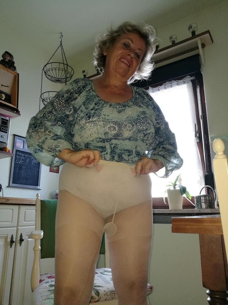 Horny granny Caro sticks a banana inside her natural pussy on kitchen chair