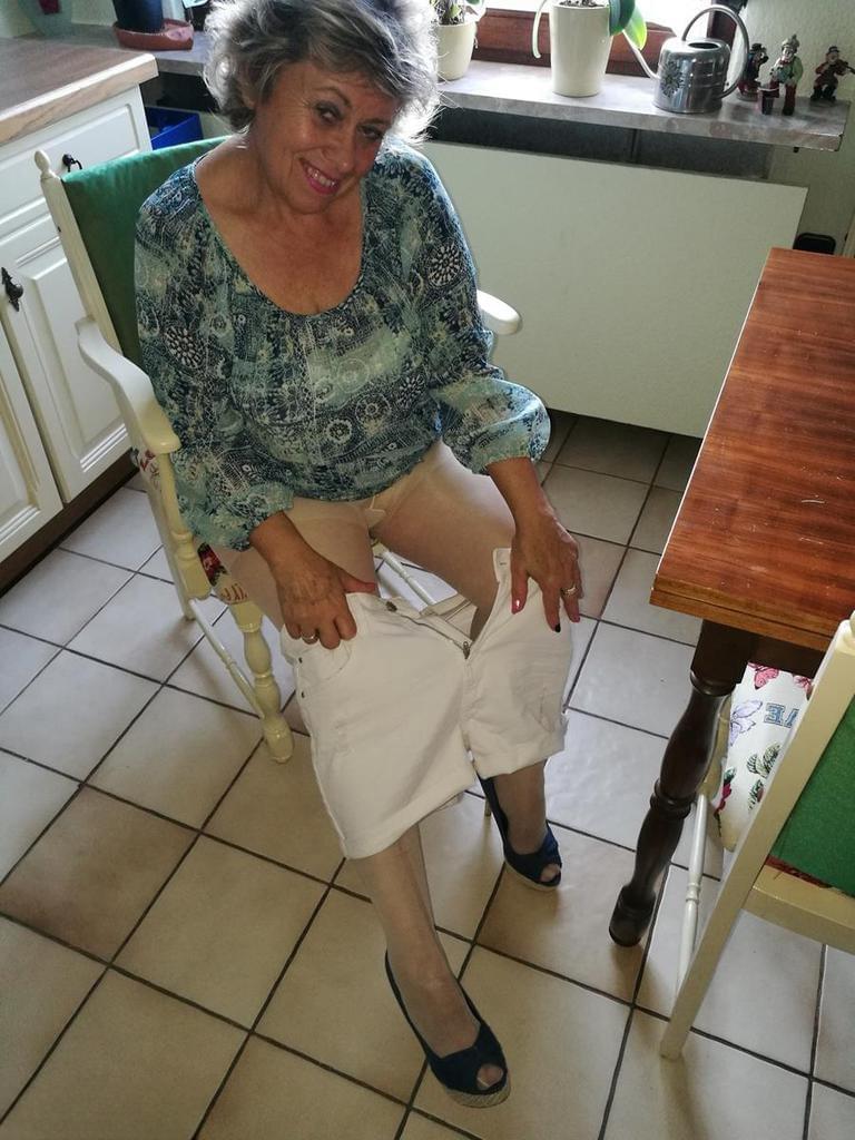 Horny granny Caro sticks a banana inside her natural pussy on kitchen chair