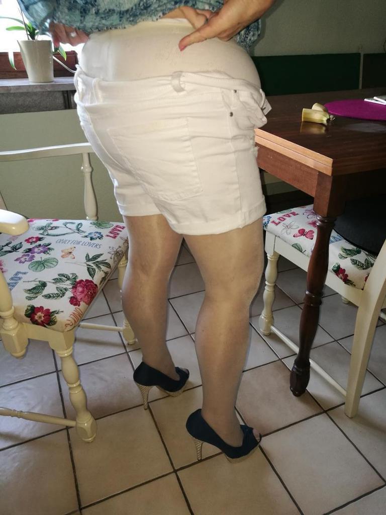 Horny granny Caro sticks a banana inside her natural pussy on kitchen chair