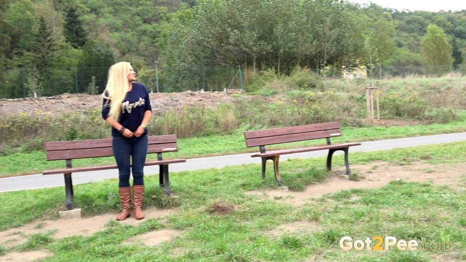 Thick blond chick Jenna Lovely squats for a piss next to bench beside the road