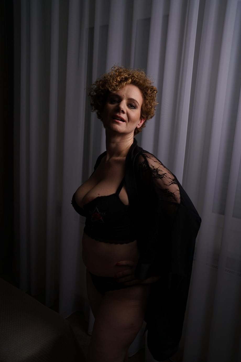Natural redhead with curly hair blows a kiss after wetting her twat in bathtub