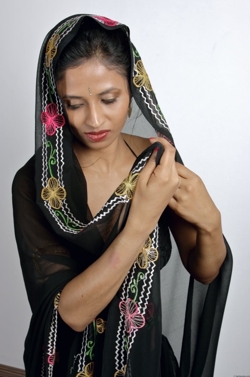 Slender Indian woman removes her sari to model in black lingerie