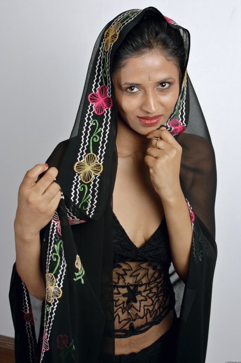 Slender Indian woman removes her sari to model in black lingerie
