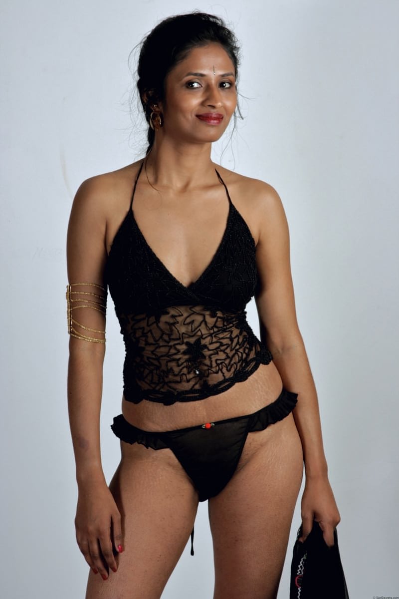 Slender Indian woman removes her sari to model in black lingerie