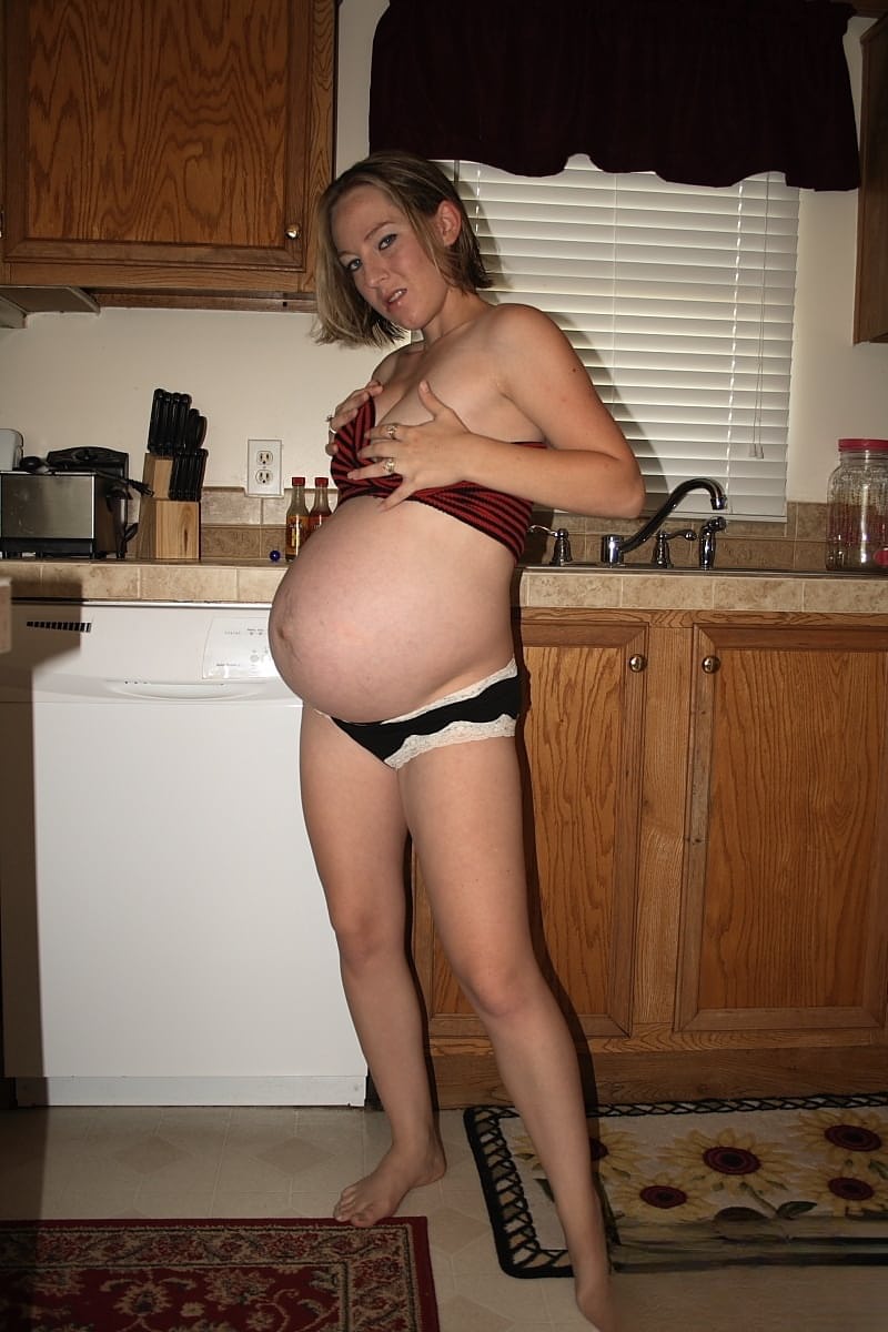 Pregnant amateur removes a tube top before slipping out of sexy panties
