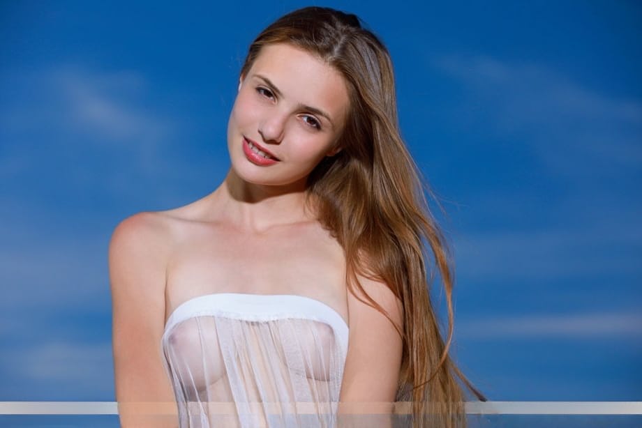 Beautiful teen Elle Tan sheds see thru attire for great nude poses atop a hill