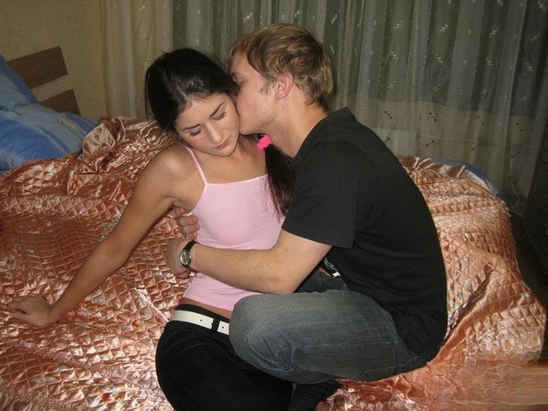 Young couple undresses before having sexual intercourse on their shared bed