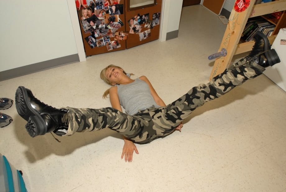 Blonde teen pulls down camo pants before having her tight ass flogged