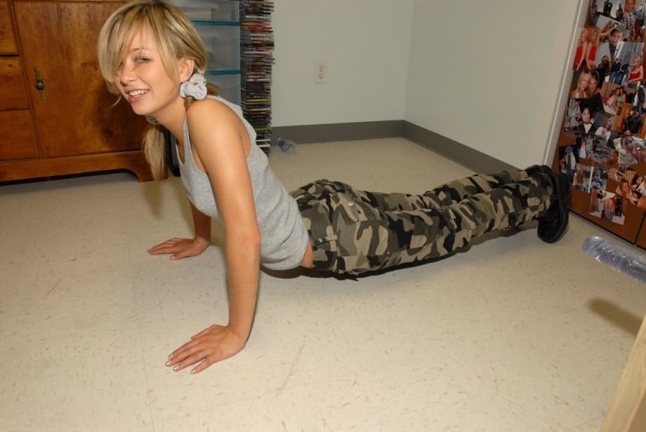 Blonde teen pulls down camo pants before having her tight ass flogged