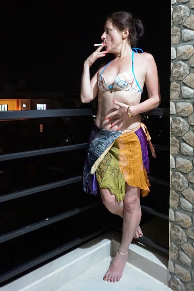 Mature woman Diana Ananta smokes a cigarette while exposing her snatch