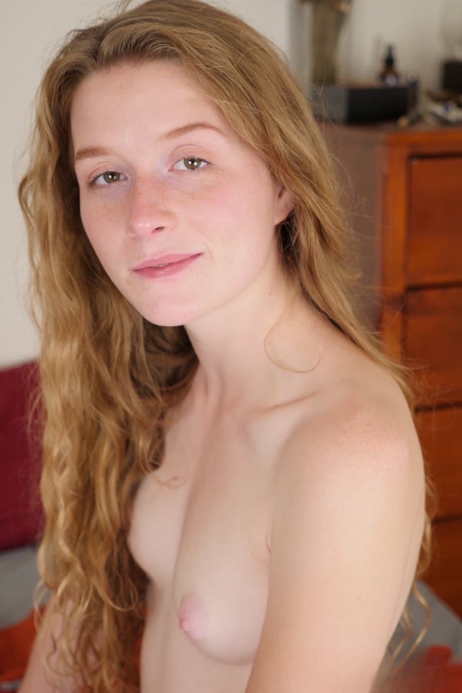 Pale redhead Karina Pontiac slips off her robe to model totally naked on bed