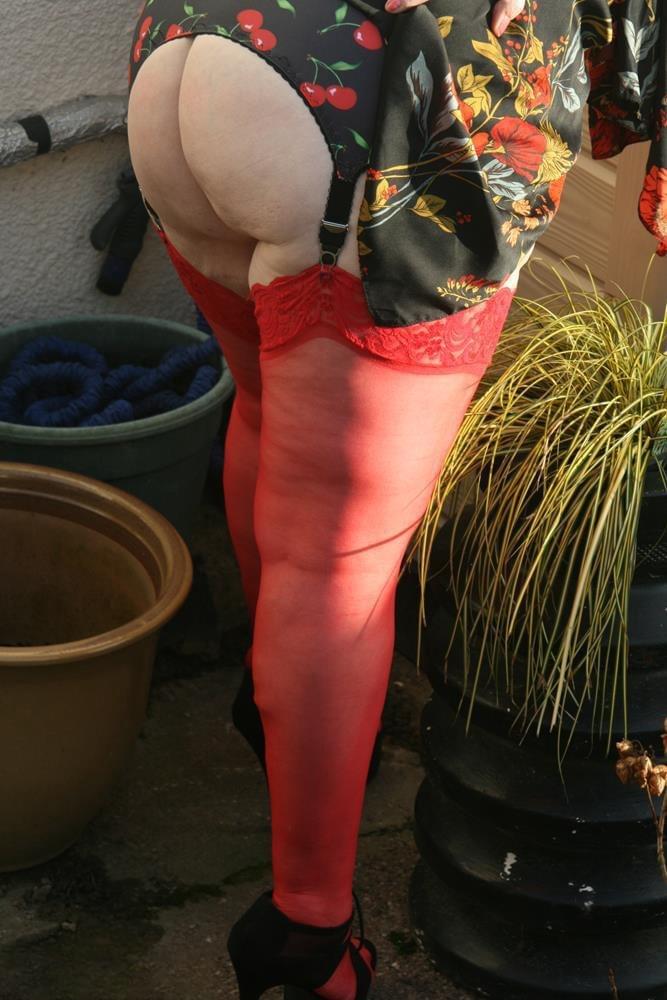 Naughty granny shows her tits and twat in backyard wearing red stockings