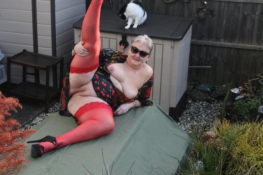 Naughty granny shows her tits and twat in backyard wearing red stockings