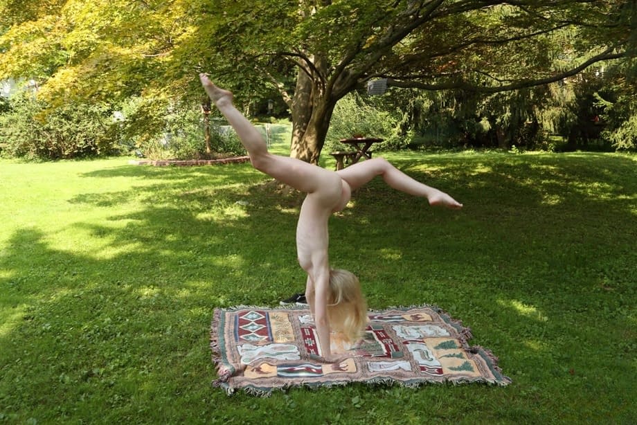 Cute blonde Emma Starletto shows off her flexibility while naked in the yard