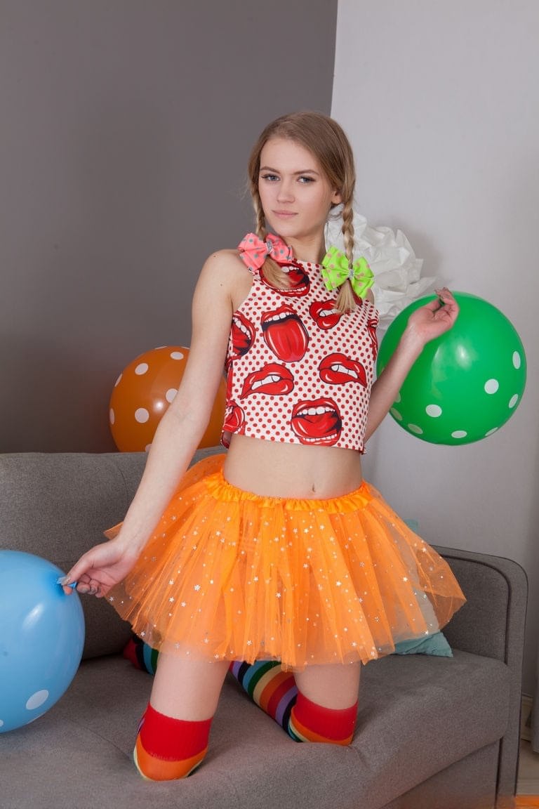 Skinny teen Lili removes her clothes and long socks to pose nude amid balloons