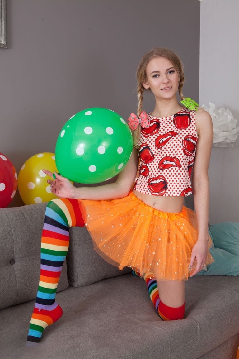 Skinny teen Lili removes her clothes and long socks to pose nude amid balloons