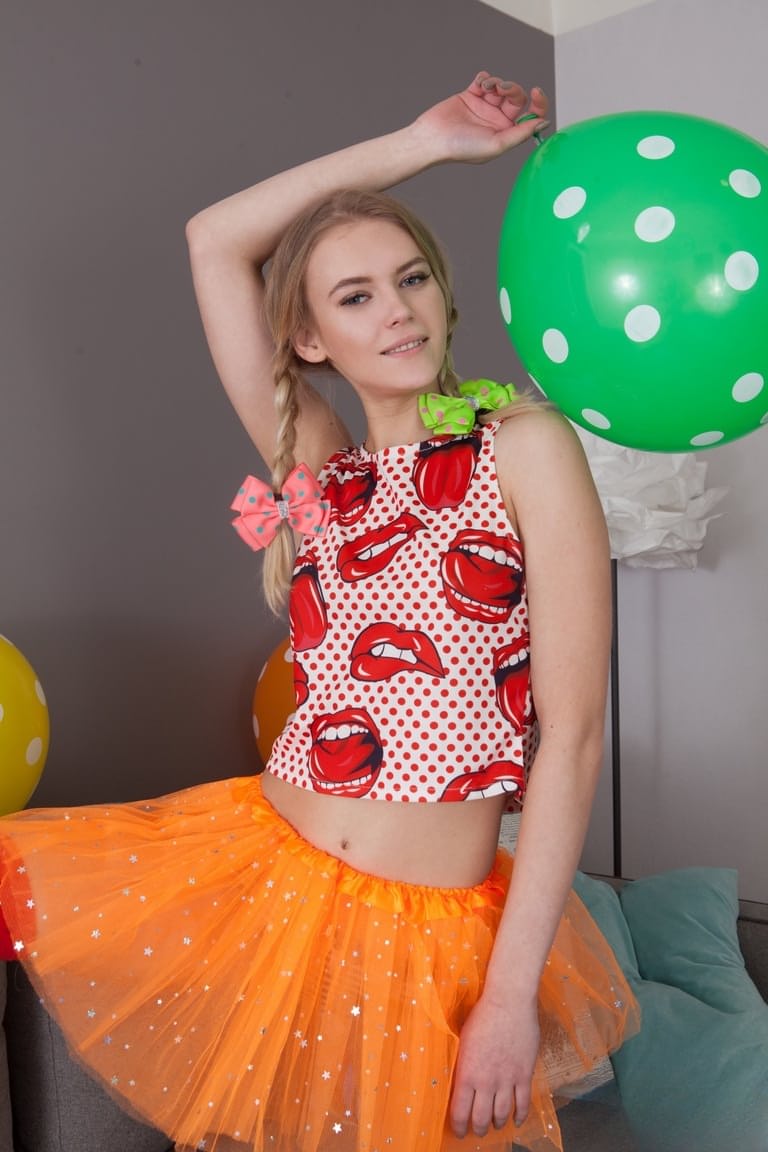Skinny teen Lili removes her clothes and long socks to pose nude amid balloons