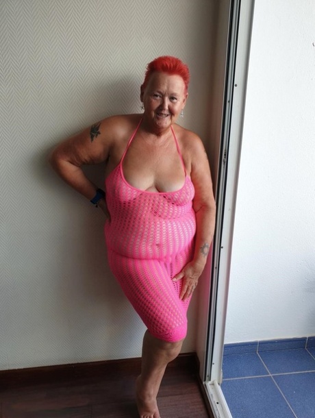 Fat nan with short red hair finger spreads her pussy on oceanside balcony