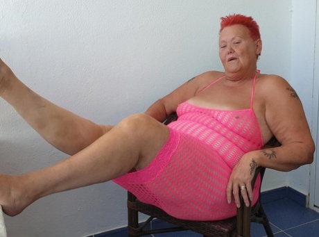 Fat nan with short red hair finger spreads her pussy on oceanside balcony