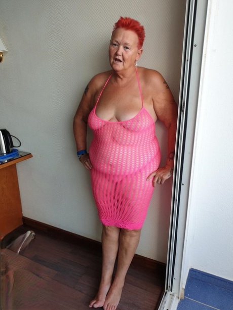 Fat nan with short red hair finger spreads her pussy on oceanside balcony