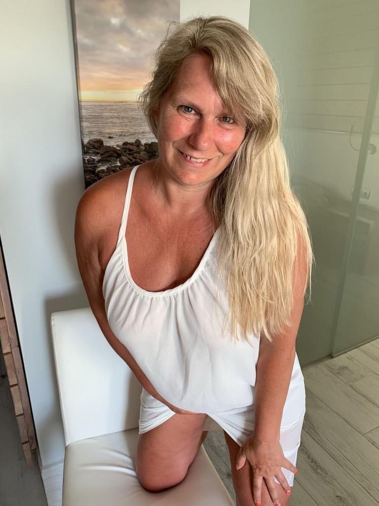 Thick older woman Sweet Susi exposes tan lined tits after hiking up her dress