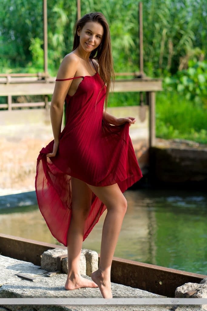 Beautiful teen Alisa Amore disrobes for nude solo poses near a dam