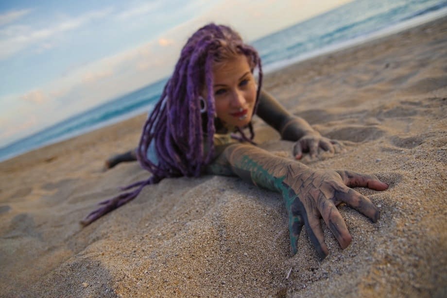 Heavily tattooed girl releases tiny tits from bikini top on a sandy beach