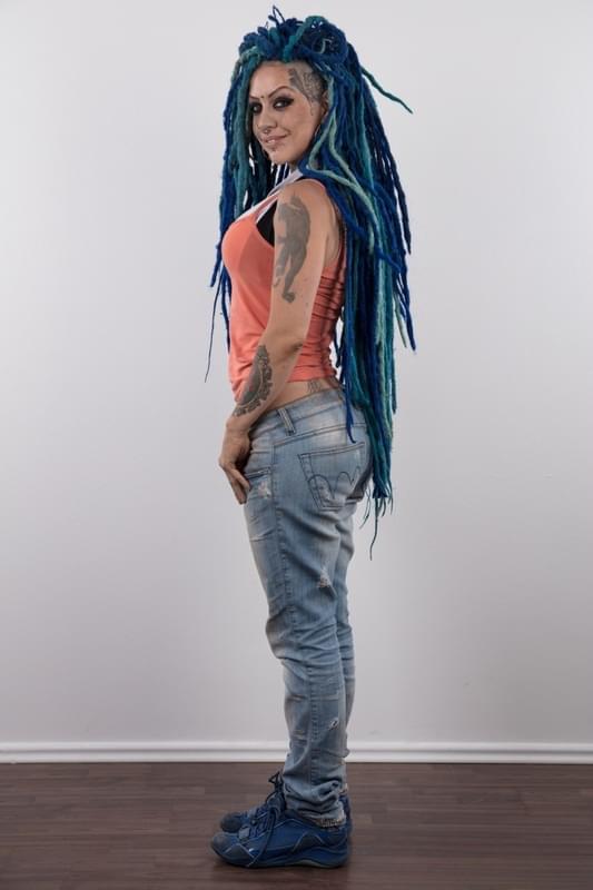 Punk girl with a headful of dyed dreads stands naked in her modelling debut