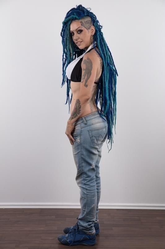 Punk girl with a headful of dyed dreads stands naked in her modelling debut