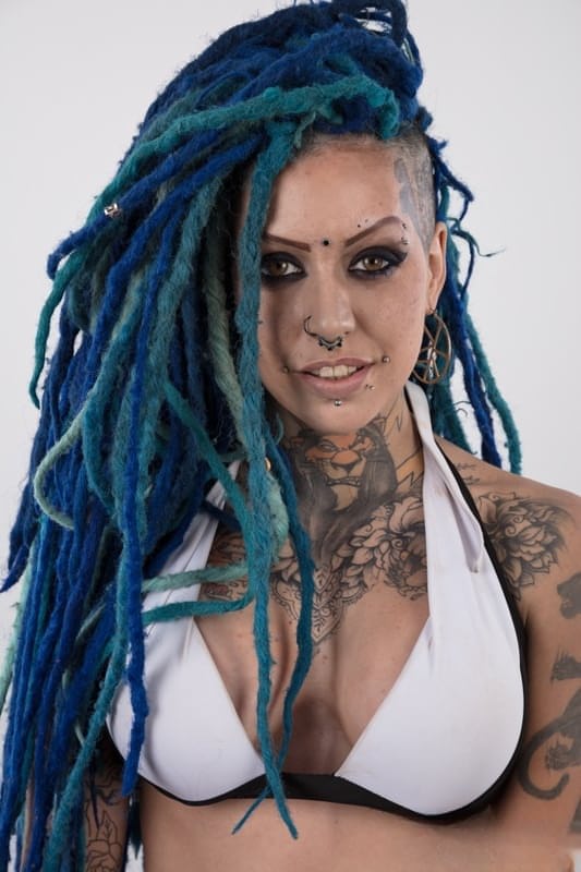 Punk girl with a headful of dyed dreads stands naked in her modelling debut