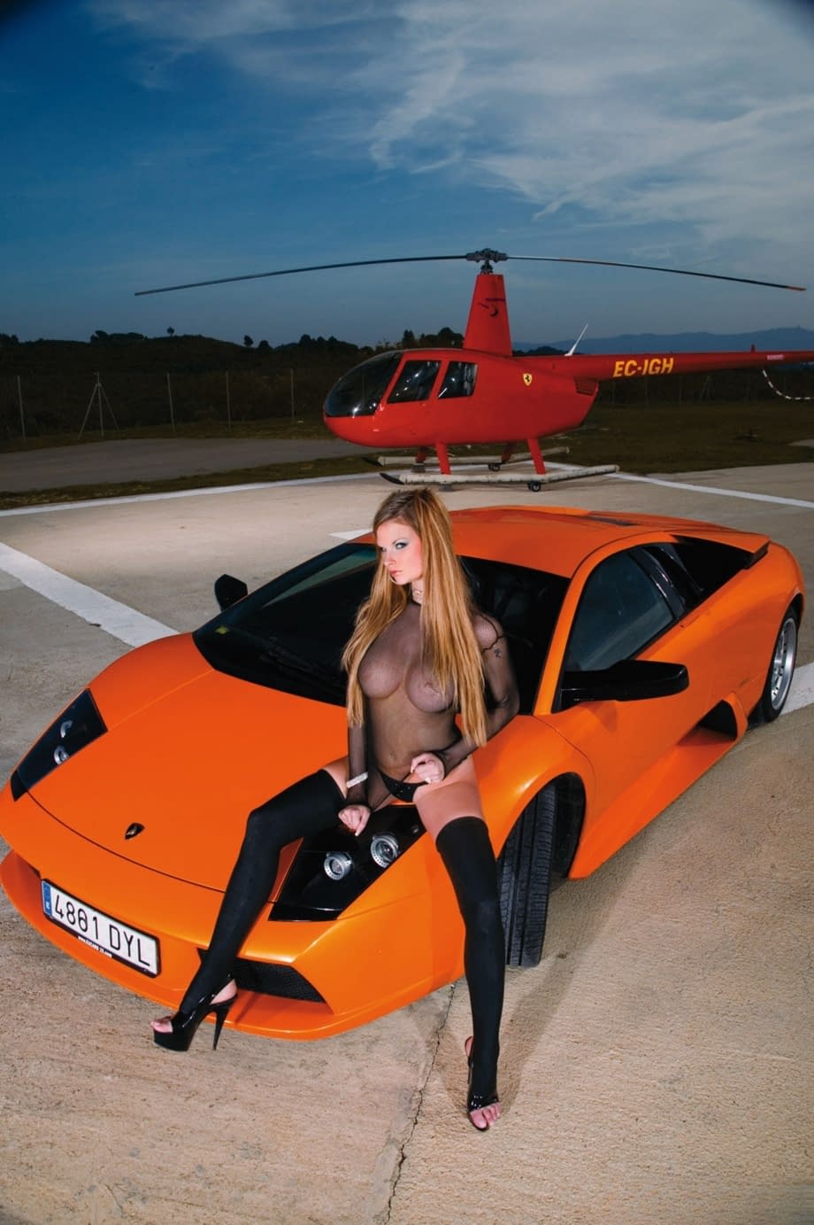 Redhead pornstar in black stockings gets banged on the hood of sports car