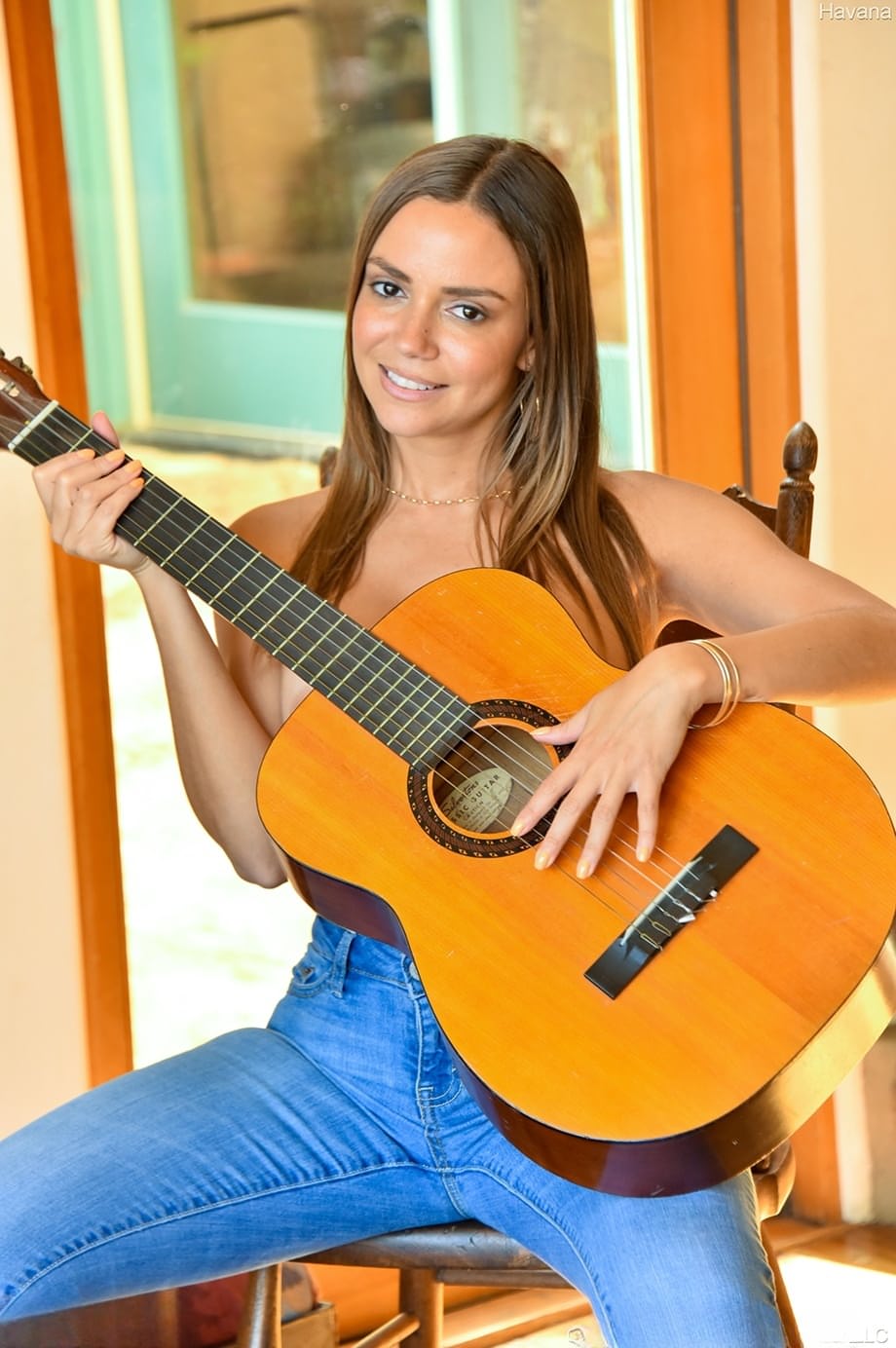 Topless girl slips faded jeans over her phat ass before strumming a guitar