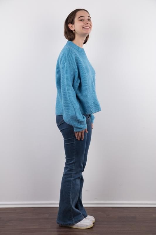 Amateur model Uliana stands naked after removing a sweater and blue jeans