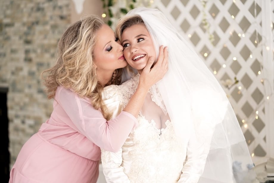 Carolina Sweets is affixed with a garter before a lesbian wedding to Julia Ann