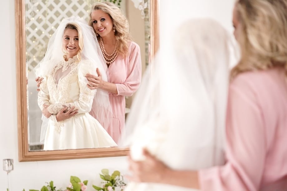 Carolina Sweets is affixed with a garter before a lesbian wedding to Julia Ann