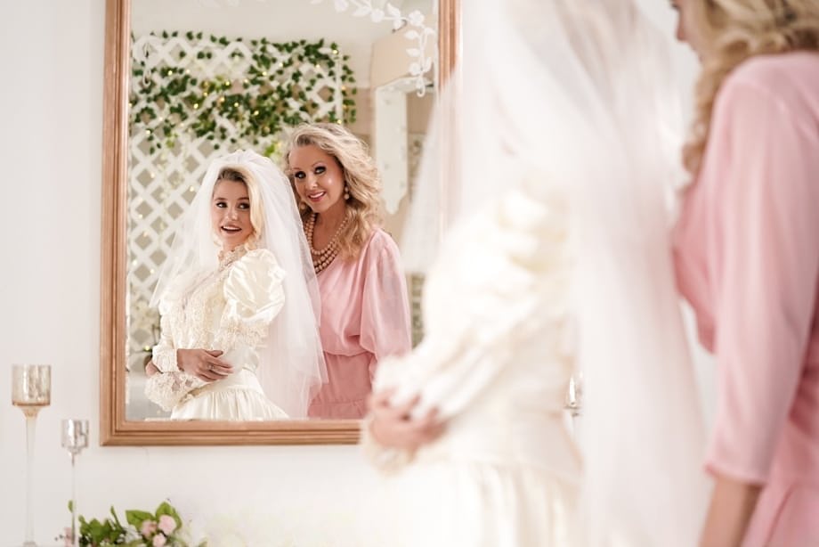Carolina Sweets is affixed with a garter before a lesbian wedding to Julia Ann