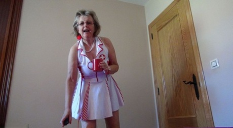 Old lady Abby Roberts frees sagging tits from nurse outfit before dildo riding