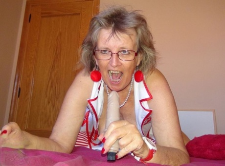 Old lady Abby Roberts frees sagging tits from nurse outfit before dildo riding