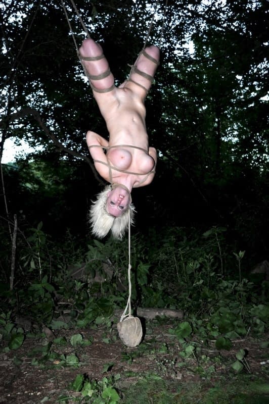 Blonde teen Cherry Torn is hung upside down during BDSM session