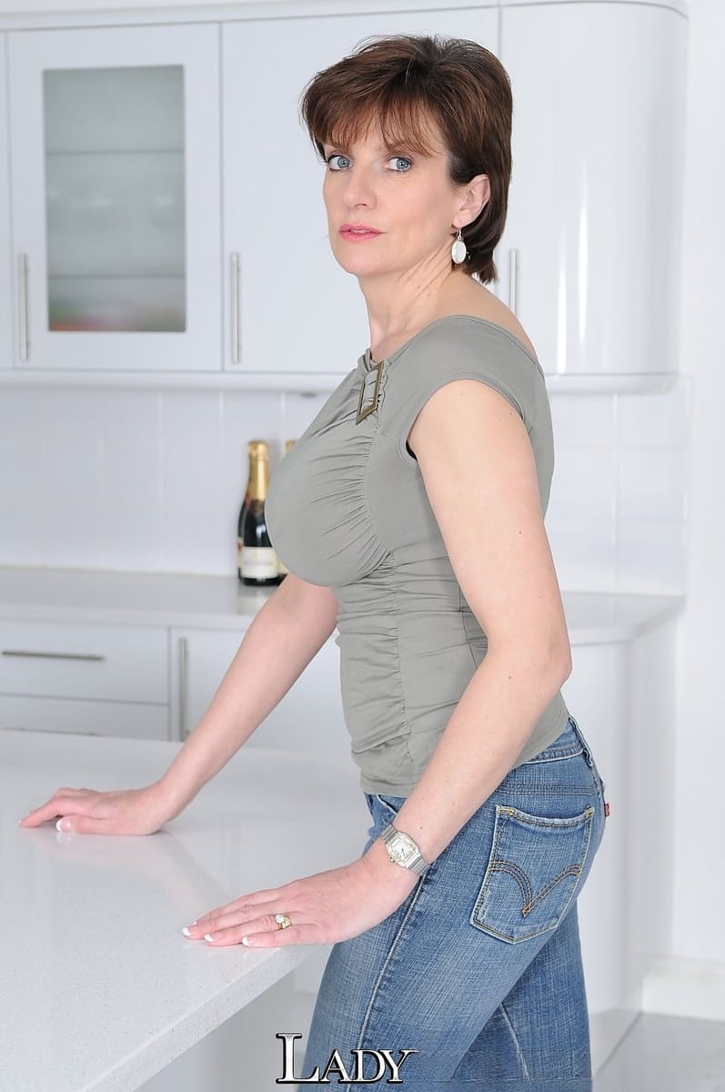Mature wife Lady Sonia flaunts big tits braless in t-shirt in the kitchen