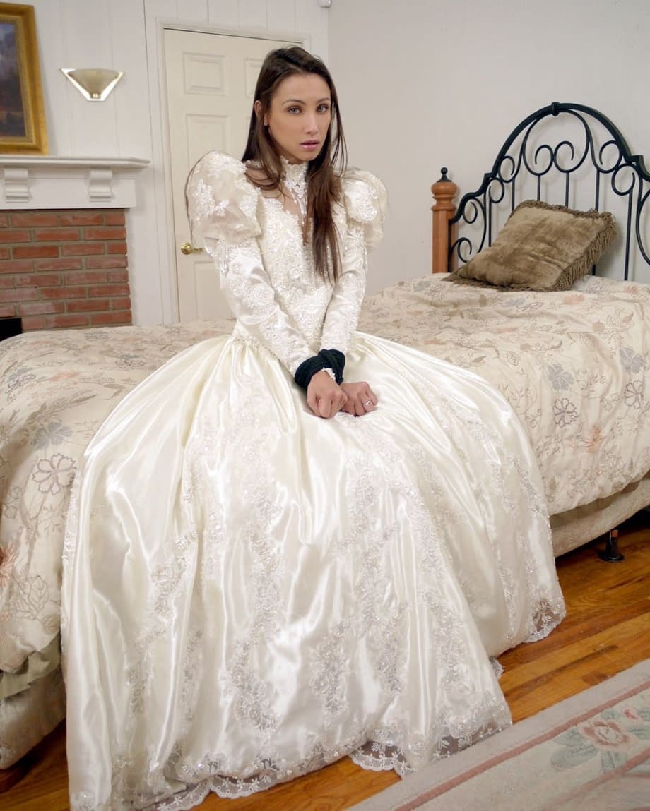 Brunette bride Celeste Star is ballgagged and tied up in her wedding dress