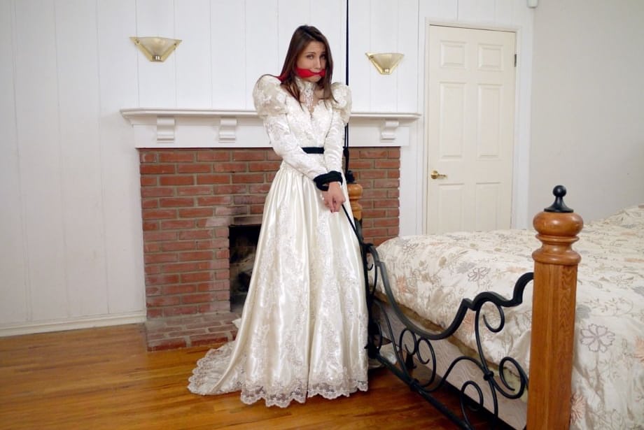 Brunette bride Celeste Star is ballgagged and tied up in her wedding dress