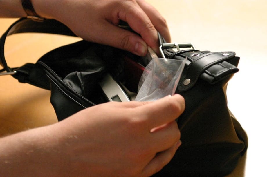 Blonde girl in a black skirt and white blouse is placed in handcuffs