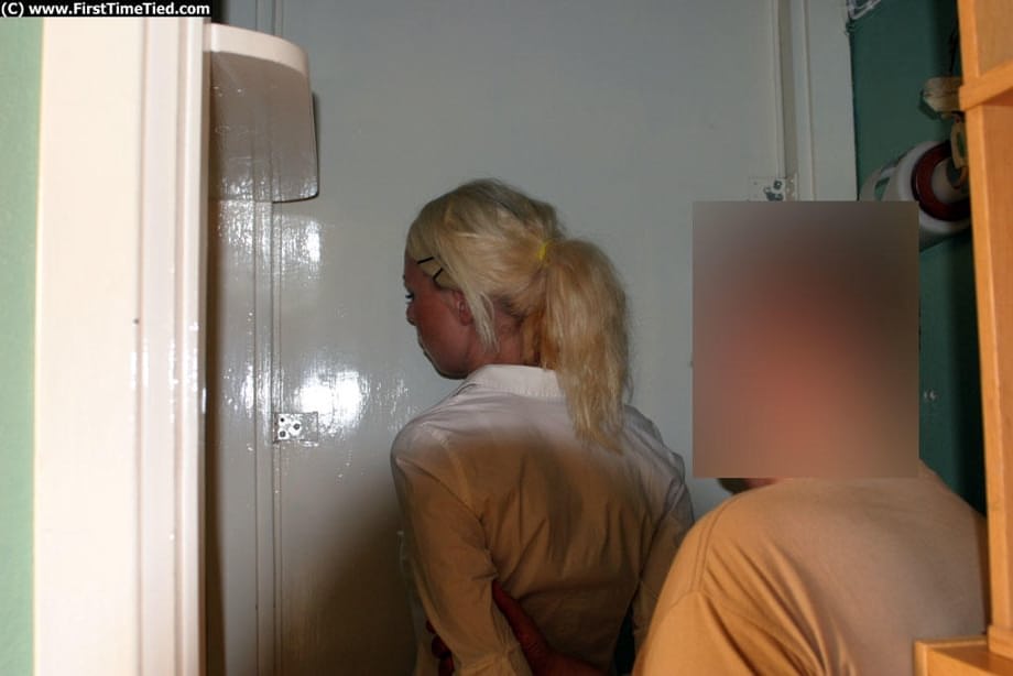 Blonde girl in a black skirt and white blouse is placed in handcuffs