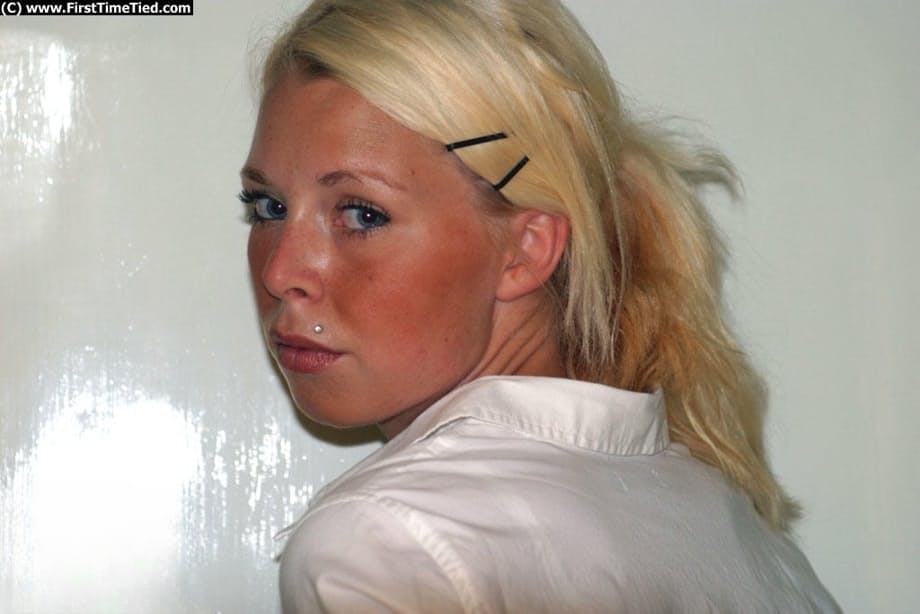 Blonde girl in a black skirt and white blouse is placed in handcuffs