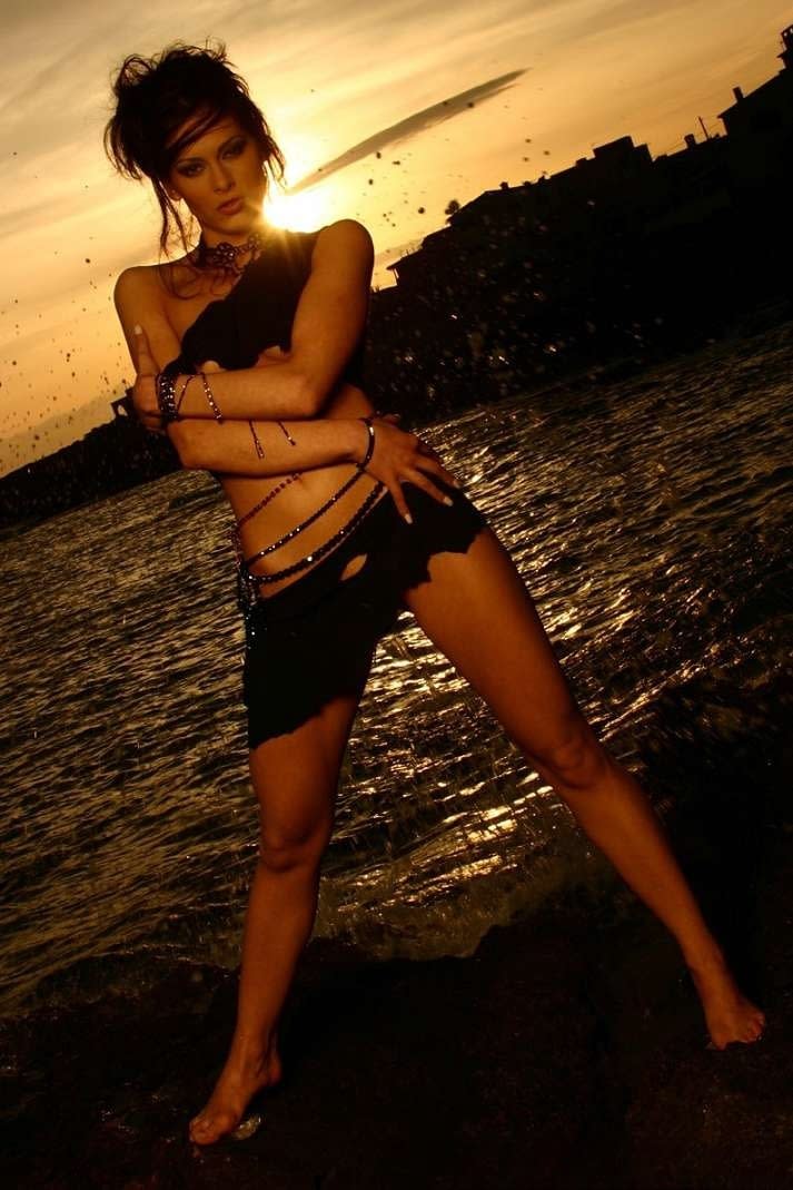 Solo model Evelyn Lory exposes her tiny tits as she sun sets at beach